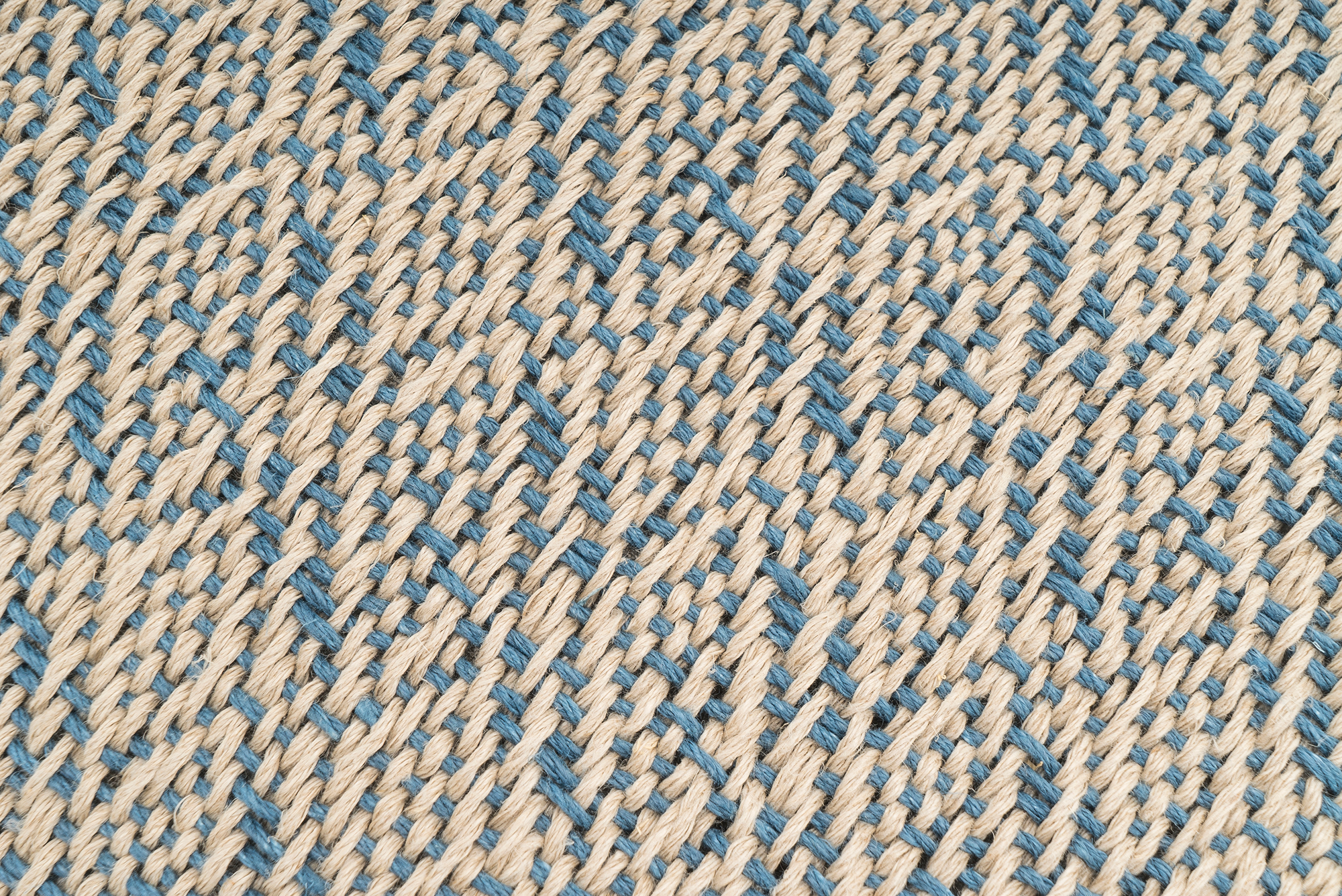 Eco-conscious hemp pillowcase, handwoven with diamond design, beige and blue hues.